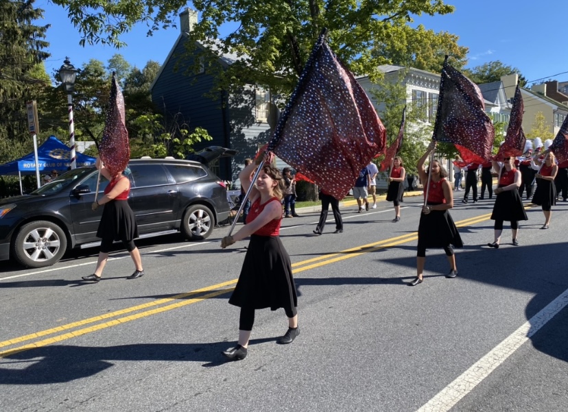 Members of the Color Guard twirled their flags as they led the Marching Band down the street. 
