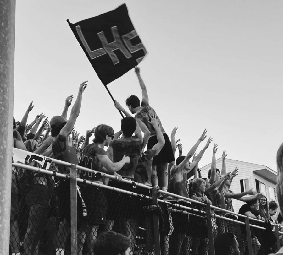 Member of the tribe Brady Brouillard, raises the LHS flag above the students to get everyone into the Lancer Spirit.