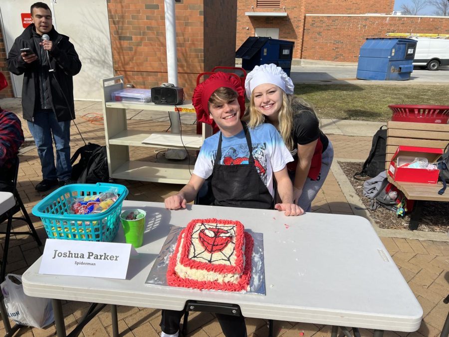 Josh Parker and Claire Thomas pose together after completing the spider   man themed cake.