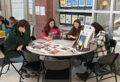 Daniela Gerardi, Taylor Gepes Carroll and Sophia Hopkins teach a student about the war in Ukraine. 