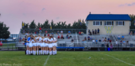 Girls varsity soccer team huddled for team prayer before fall 2021 game.