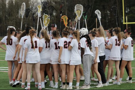 The Linganore girls varsity lacrosse team huddles together before the game to prepare. 