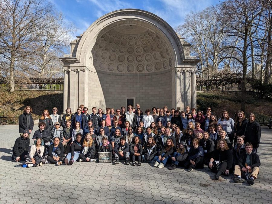 The entire band poses in front of the Naumburg Band Shell in Central Park. The band will play a piece called On the Mall that originally premiered in this venue one hundred years ago at their band concert.