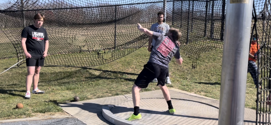 Logan Rich throws his shot put to practice his technique for an upcoming meet.