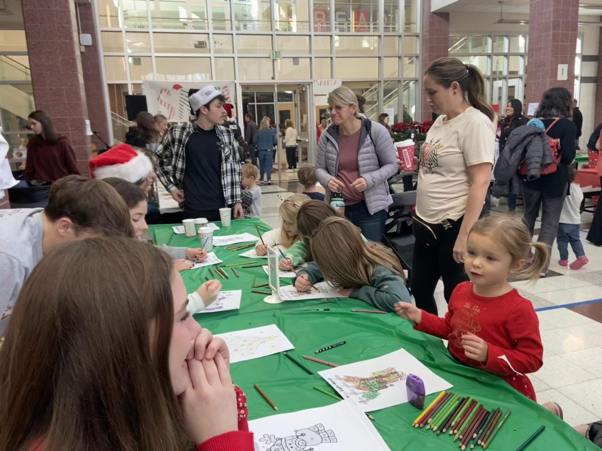 Kids line benches to participate in holiday mad libs and coloring by sight words with the National English Honor Society (NEHS).