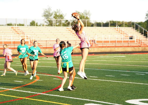 Linganore powderpuff senior football players (Class of 2024) jumping into the air to catch the ball. (Photo by Paul Madariaga - used with permission)