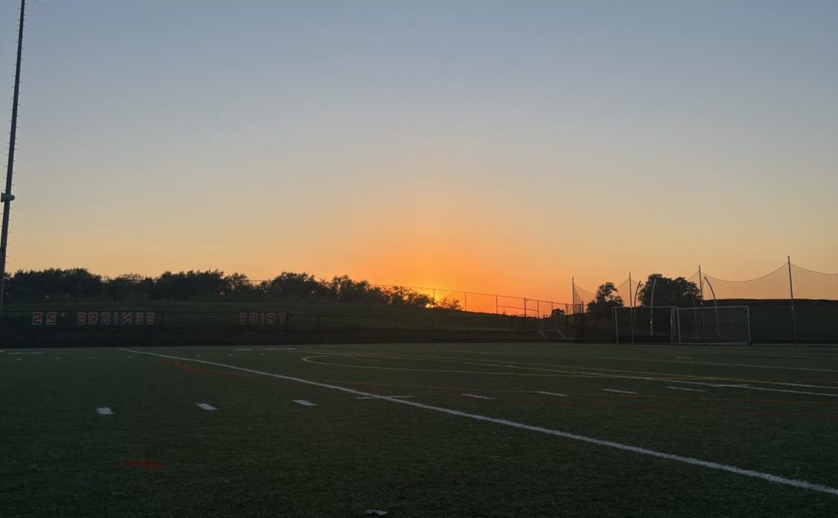 The sun rises over the LHS football field during Senior Sunrise.