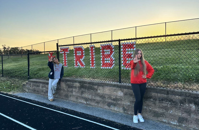 Seniors Gigi Broccolino and Charley Grimet pose up by the Tribe sign to show school spirit.