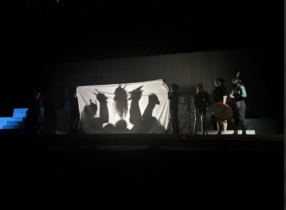 Monsters in the shadows behind a drape being fought off by Tilly (Addy Stacey) and Agnes Evans (Allie Logue)