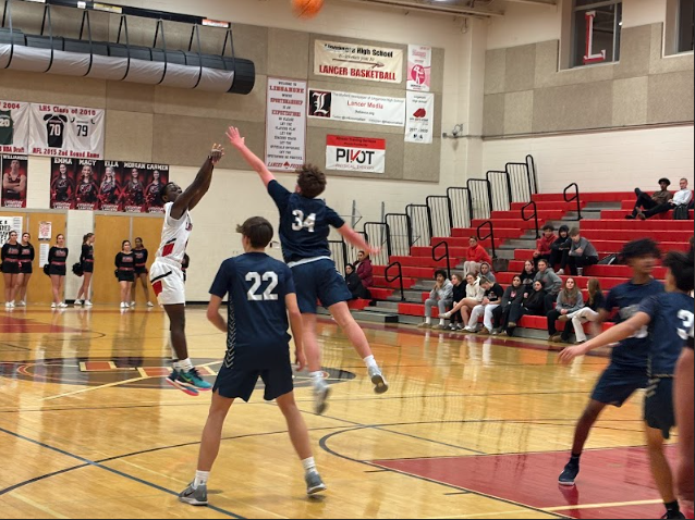 Junior Kenneth Butler shoots the ball while Number 34 tries to block.