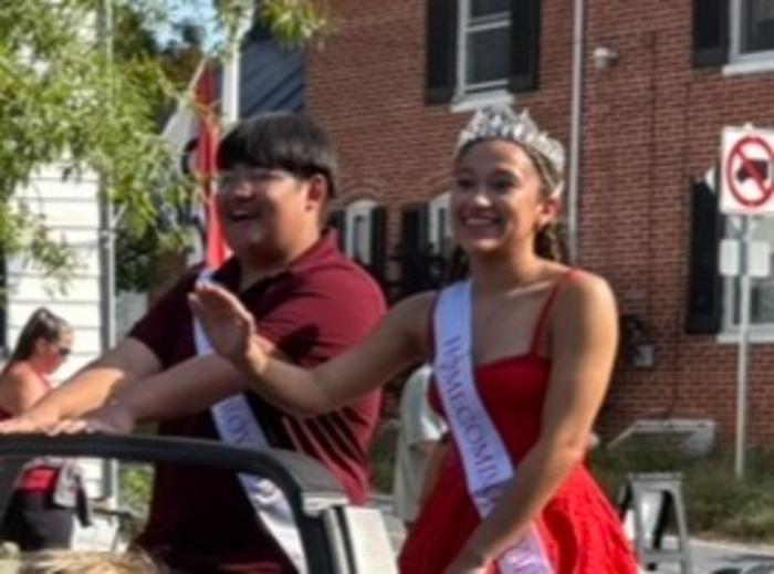 Class of 2027 court rides down main street at the homecoming parade.