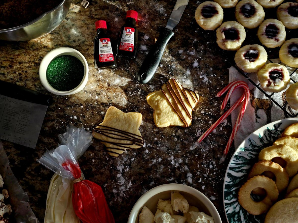 Chocolate-drizzled orange shortbread cookies cool on the counter waiting for the chocolate to set. Soon, they will be ready to be boxed and given away.