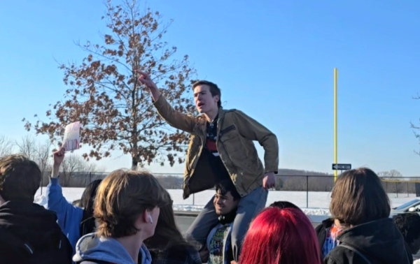 Linganore senior Harry Sauer sits on another students' shoulder while shouting protest chants.