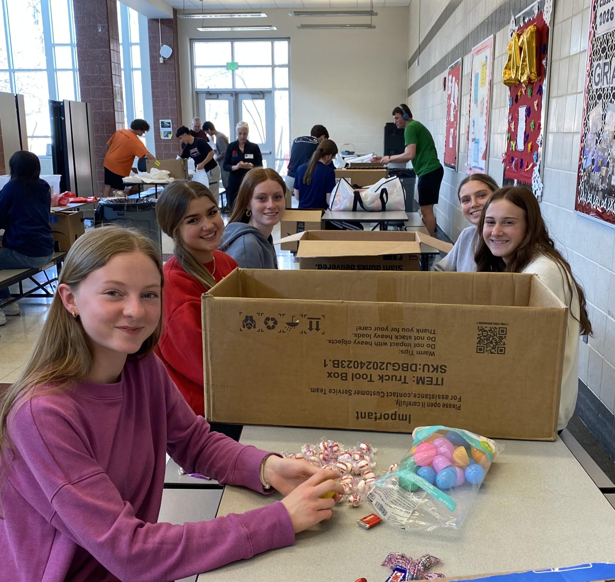 Linganore National Honor Society members who are helping fill plastic eggs with candy.