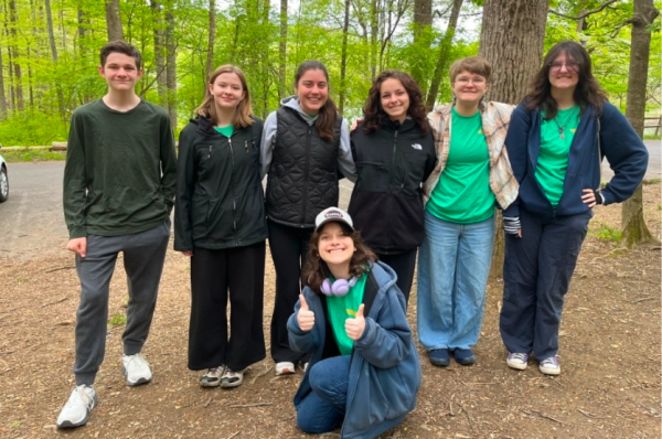 Six students and one staff member posing in front of the small body of water. (Photo courtesy of Amber McCauley)