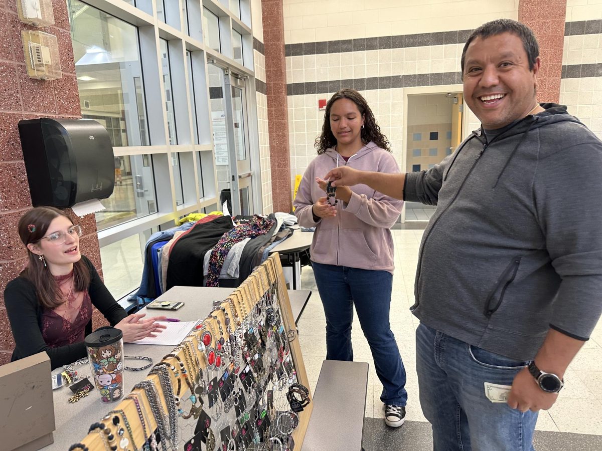 Linganore High School (LHS) junior Chloe Warner sells jewelry to patrons of the first-ever LHS thrift store during the spring carnival.